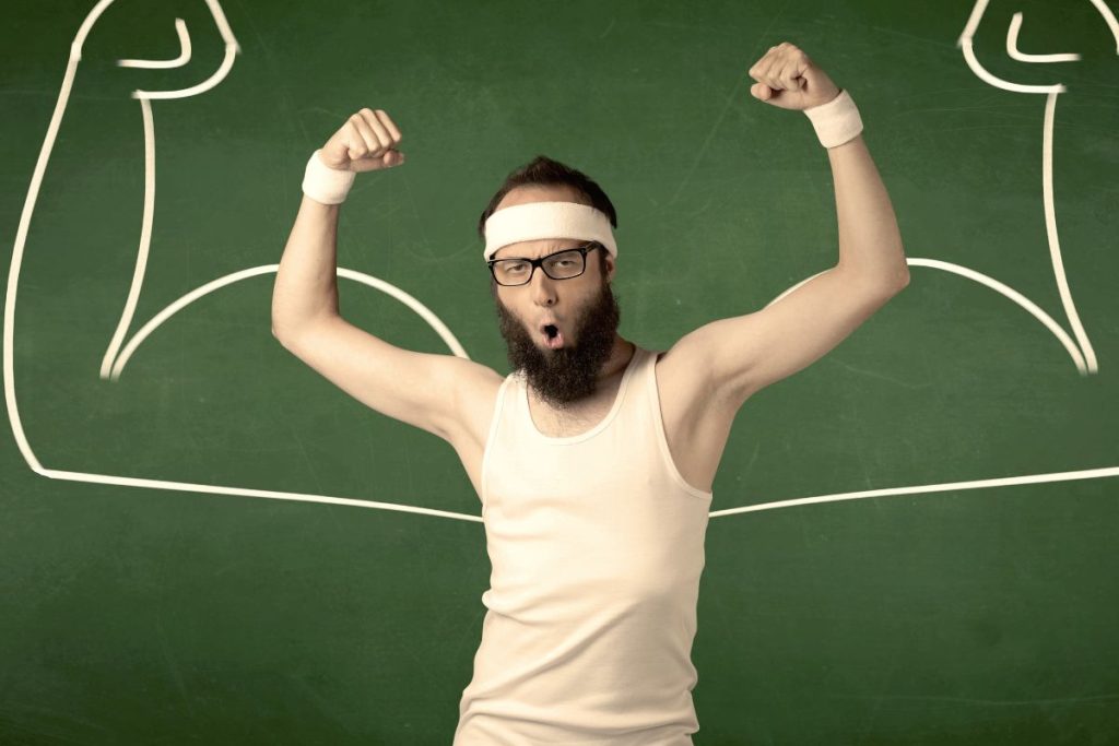 Un homme avec une barbe et des lunettes debout devant un tableau.