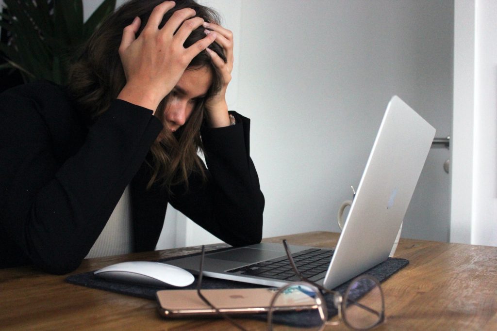 Une femme est assise à un bureau avec un ordinateur portable.
