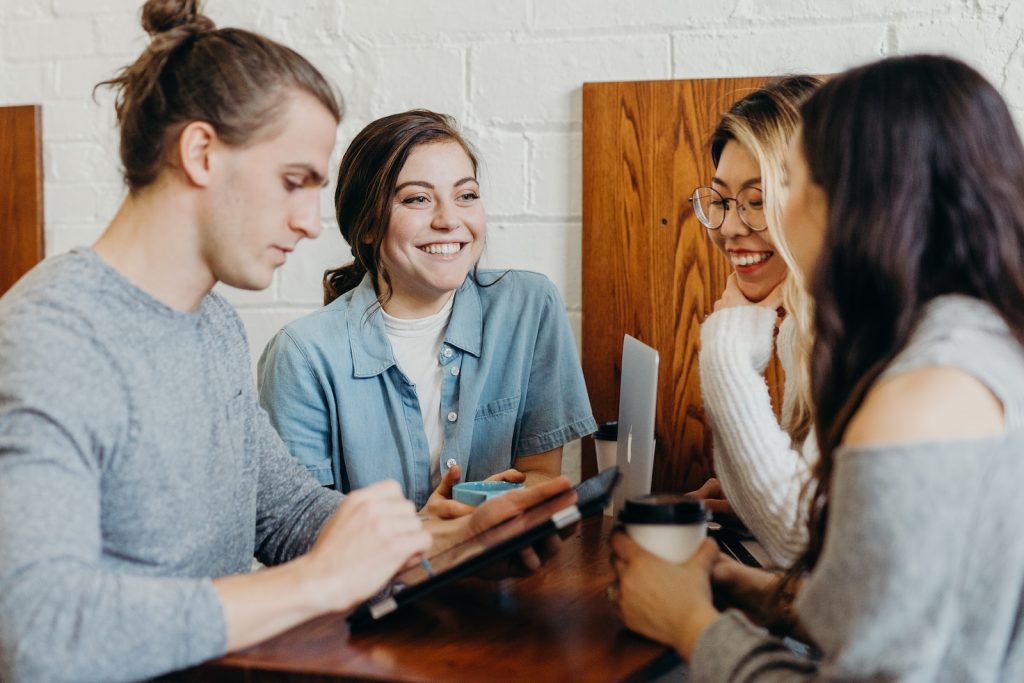 Un groupe de personnes assises autour d’une table et discutant.
