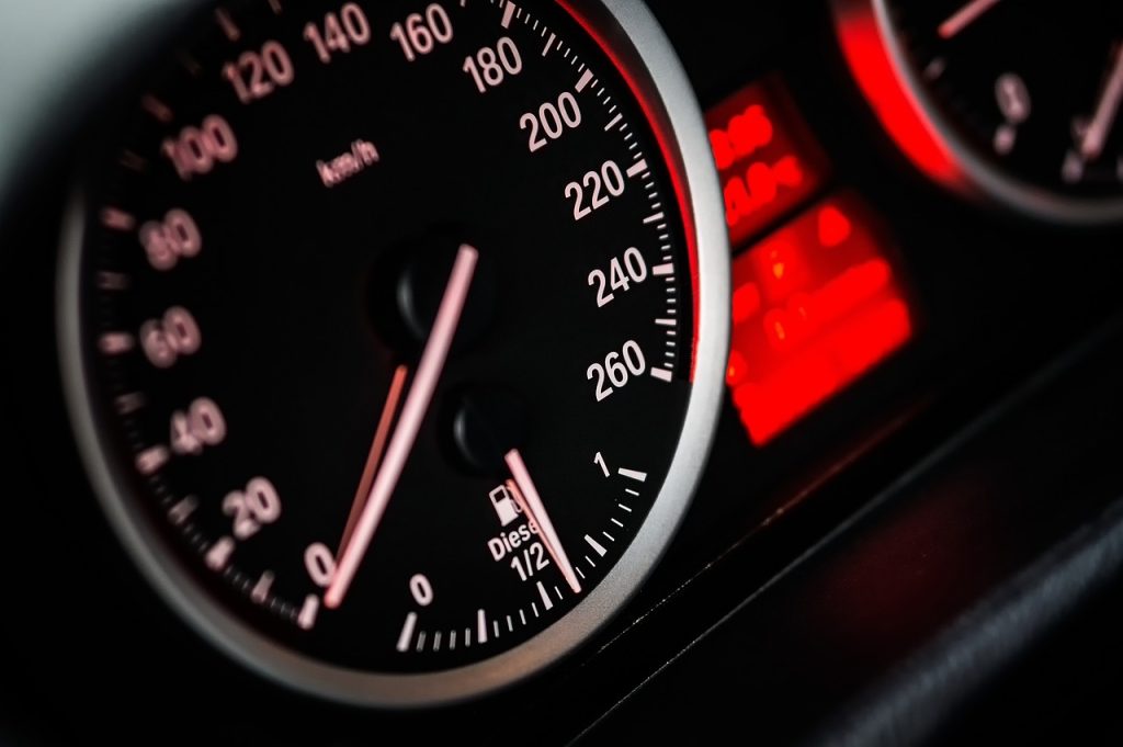 Gros plan sur le compteur de vitesse et la jauge de carburant d'une voiture, l'aiguille pointant vers 40 km/h et le niveau de carburant se situant juste au-dessus de la moitié. Les lumières rouges du tableau de bord sont visibles à l'arrière-plan.