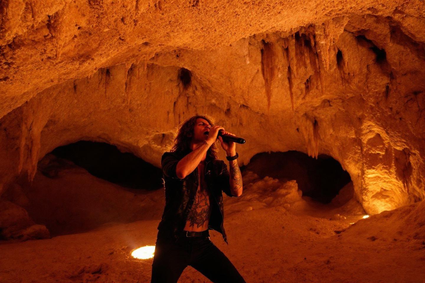 Performer chantant avec passion dans un environnement souterrain rocheux