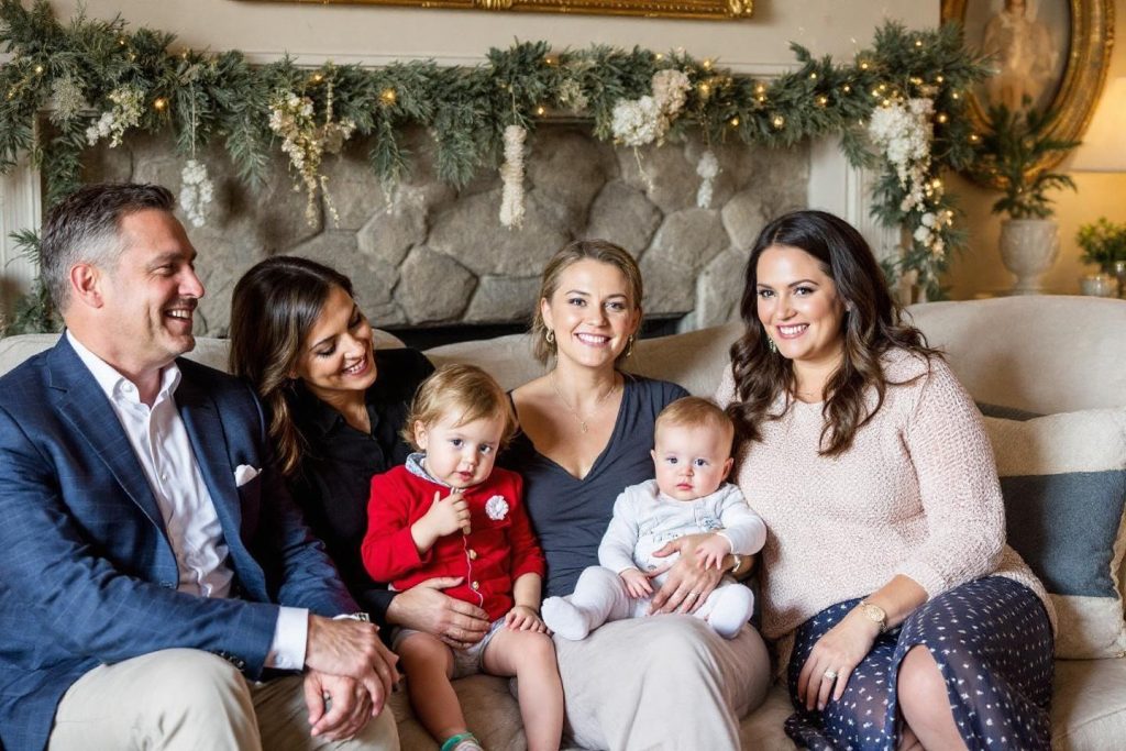 Groupe familial joyeux avec deux bébés, assis sur un canapé