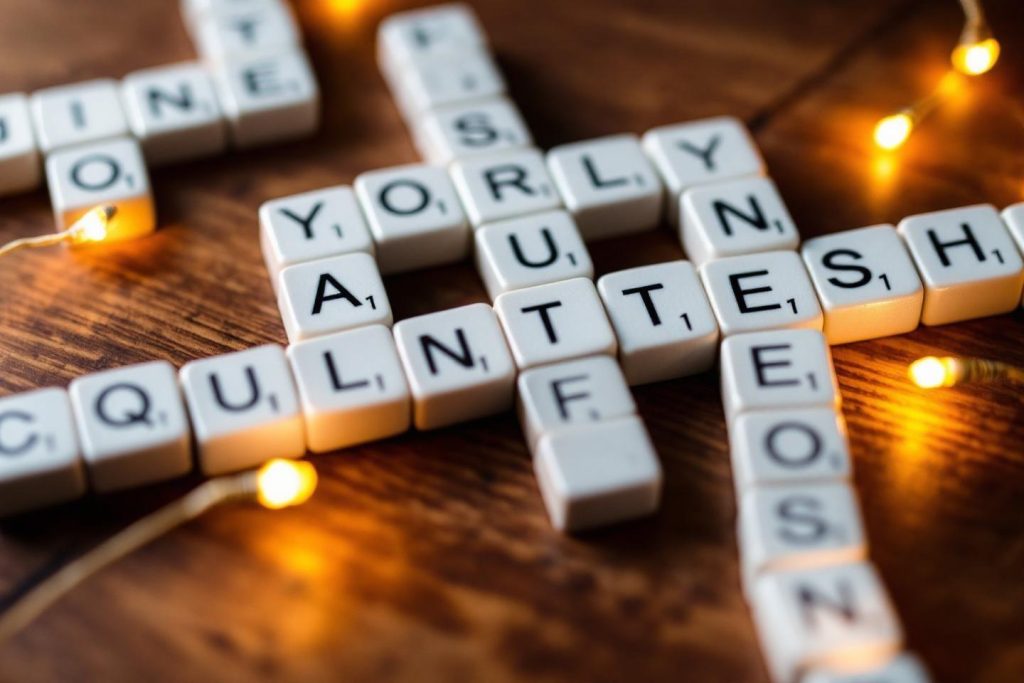 Lettres de Scrabble disposées en mots croisés avec lumières dorées