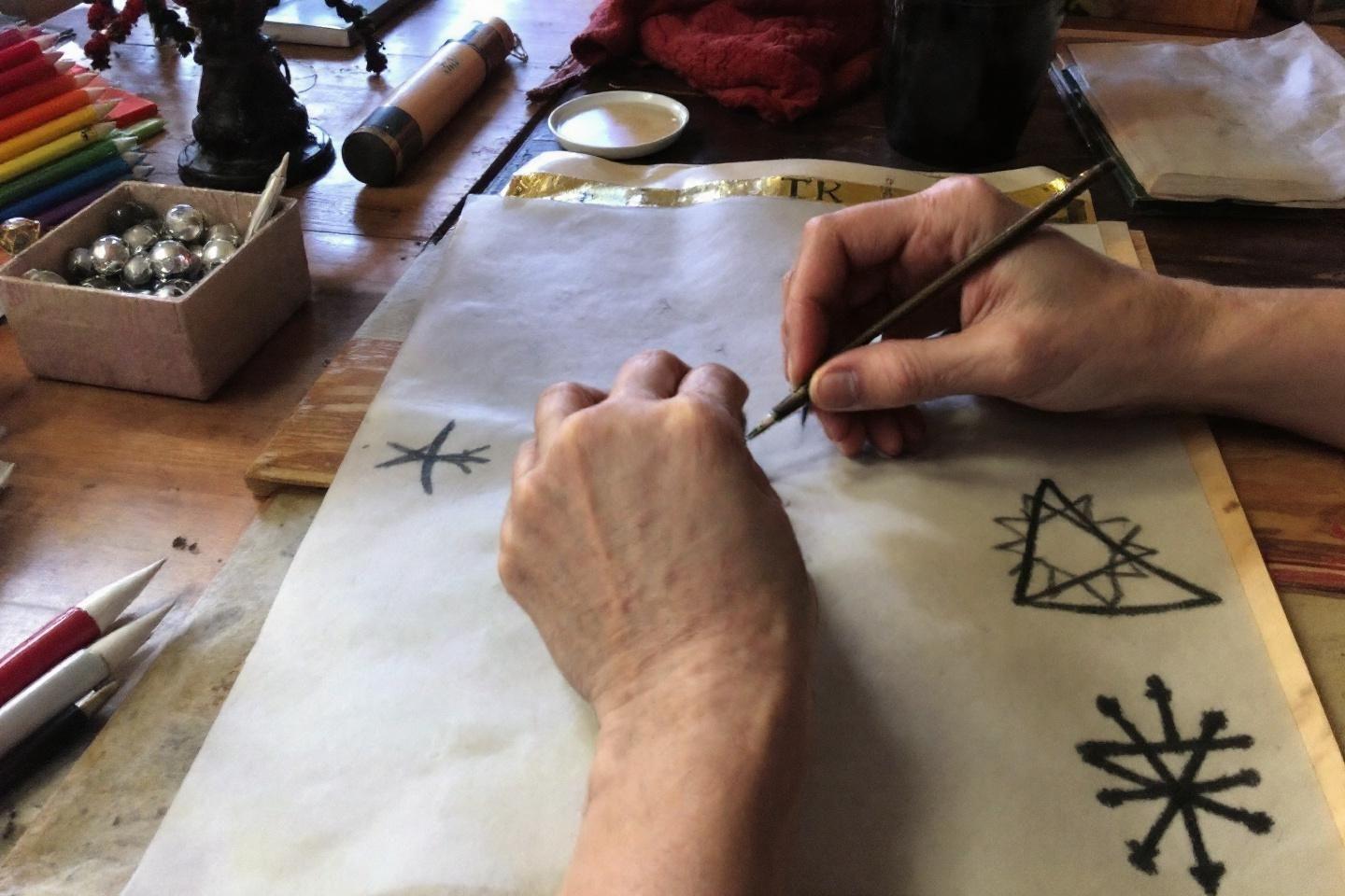 Mains dessinant des symboles géométriques sur papier avec outils