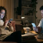 Homme et femme utilisant leurs téléphones dans un salon confortable